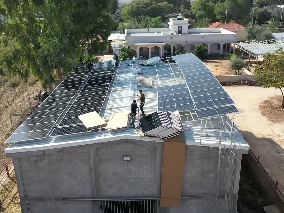 Dos instaladores colocando un panel solar en un techo